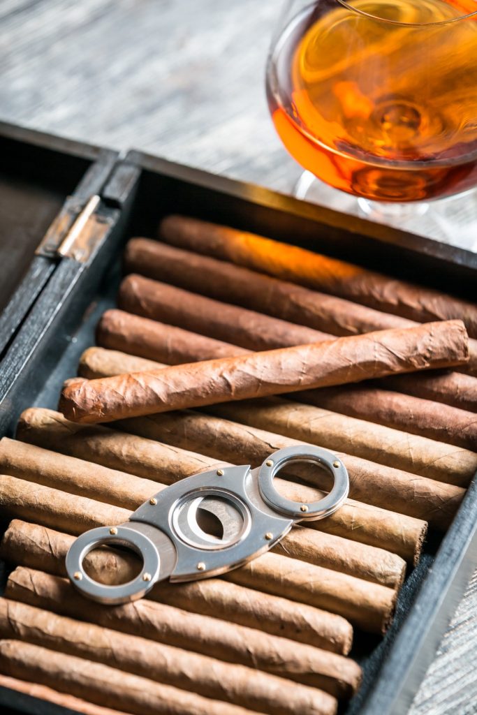 Humidor full of cigars, guillotine and cognac